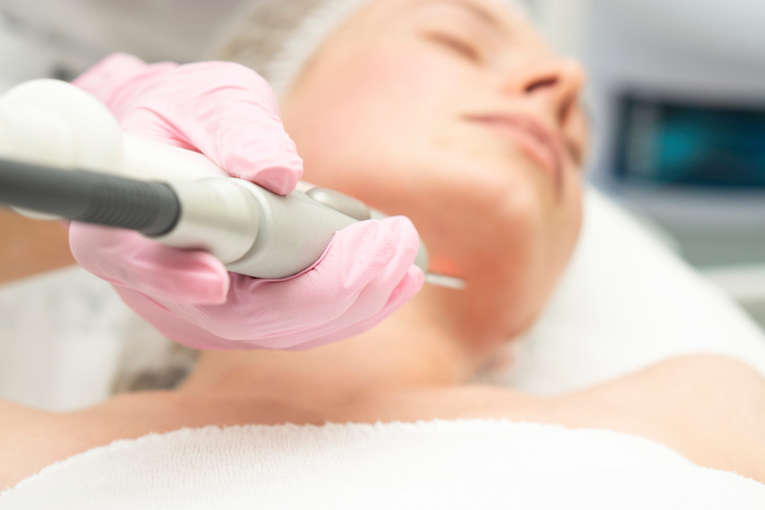 Doctor cosmetologist makes a laser dermal rejuvenation procedure